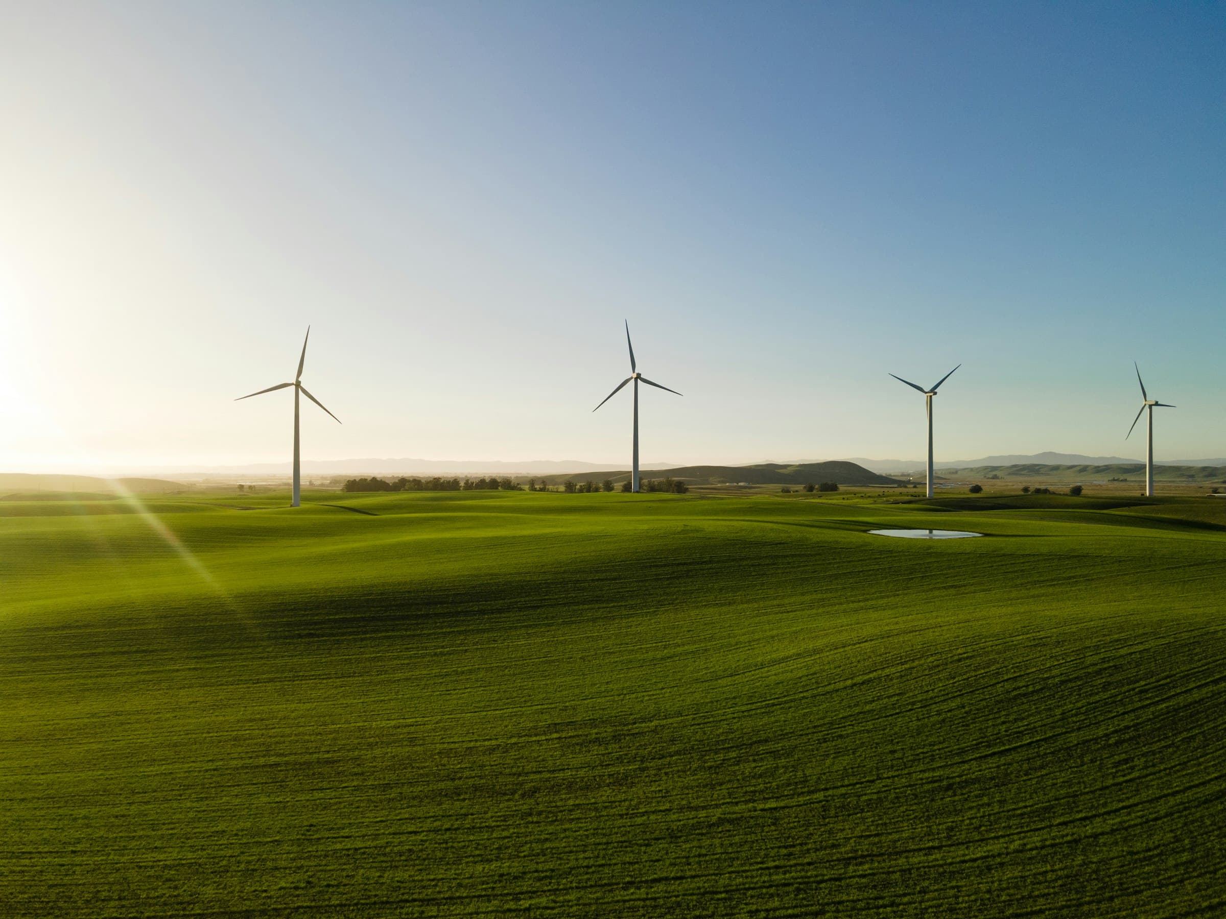 Wind turbines standing in a green field